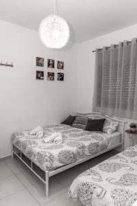 Dos mujeres acostadas en una cama en un dormitorio en סטודיו ליה - studio lia eilat, en Eilat