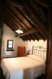 a bedroom with a white bed with a wooden ceiling at CASA TEO in Ávila