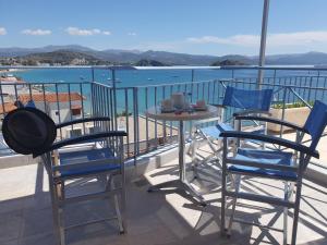 twee stoelen en een tafel op een balkon met uitzicht op het water bij Dolfin in Tolo