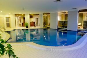 a large swimming pool in a building with a large at Spice Hotel in Kuwait