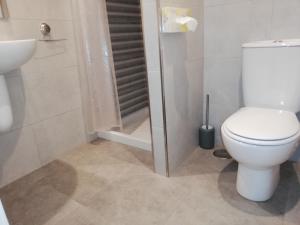 y baño con aseo y cabina de ducha. en Pensión La Intermodal, en Santiago de Compostela