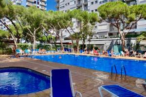 a large swimming pool with people sitting around it at Apartamento primera línea de Mar Enjoy the view in Blanes