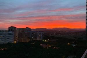 a sunset over a city with buildings and trees at Apartamento primera línea de Mar Enjoy the view in Blanes