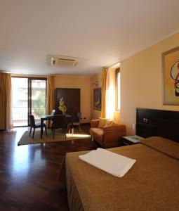 a hotel room with two beds and a living room at Panorama Hotel in Syracuse