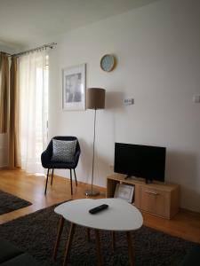 een woonkamer met een tv en een tafel bij Vörösmarty Apartman Miskolc - Belváros - downtown in Miskolc