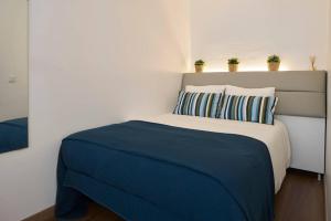 a bedroom with a bed with blue sheets and pillows at Cozy Studio Alvalade in Lisbon