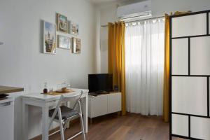 a small kitchen with a desk and a television at Cozy Studio Alvalade in Lisbon