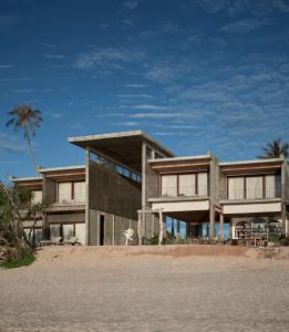 ein Haus am Strand mit einer Palme in der Unterkunft Chula Beach Resort in Khanom