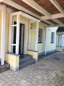 a house with a porch and stairs in front of it at Kleine Ferienwohnung bei Kappeln an der Schlei in Kappeln