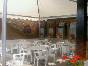 Residence Lores 2 - Go Vacanze في ماريليفا: مجموعة طاولات وكراسي تحت خيمة بيضاء