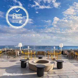 Allegro Madeira - Adults Only في فونشال: فناء به طاولات وكراسي ومطل على المحيط