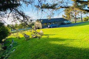 a house in a field with a green yard at Lake District romantic get away in 1 acre gardens off M6 in Penrith