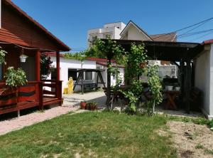 a backyard with a pergola and a house at Casa Cris Will in Mamaia Nord