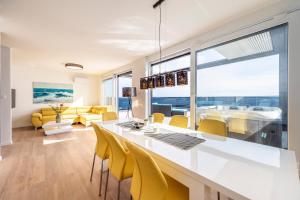 a dining room and living room with a table and yellow chairs at Mediteran luxury penthouse with jacuzzi in Mandre