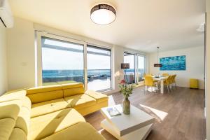 un soggiorno con divano giallo e tavolo di Mediteran luxury penthouse with jacuzzi a Mandre