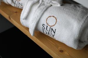 a towel with the words sun way written on it at Sunday Boutique Hotel in Nea Stira