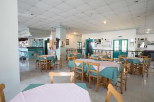 DebbieXenia Hotel Apartments في بروتاراس: غرفة طعام مع طاولات وكراسي في مطعم