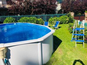 a pool in a yard with two chairs and a ladder at Sportinghouse in Garessio