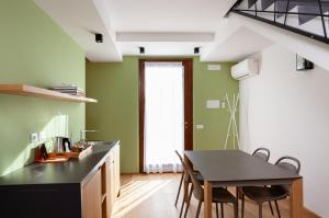 a kitchen with green walls and a table and chairs at A3Passi in Ancona