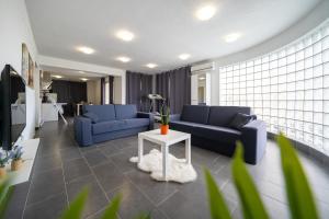 - un salon avec des canapés bleus et une table dans l'établissement Holiday Apartments Amarilis, à Pakoštane