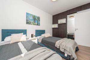 a bedroom with two beds and a bathroom at Mediteran luxury penthouse with jacuzzi in Mandre
