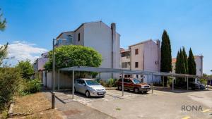 a parking lot with a car parked in front of a building at Rona Apartment Zdravko in Barbariga