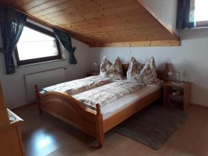 ein Schlafzimmer mit einem großen Bett und einer Holzdecke in der Unterkunft Ferienwohnungen Eggarter in Fresach