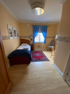 a small bedroom with a bed and a window at Broby Gästgivaregård in Sunne