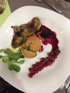 a white plate with meat and vegetables on a table at HOSTEL CPPI Vest in Buşteni +35 photos