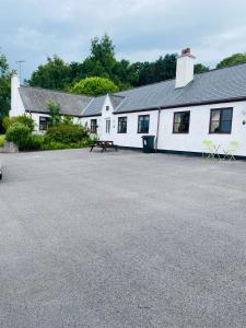 a white building with a picnic table in front of it at Conwy Valley Hotel Cottages in Conwy