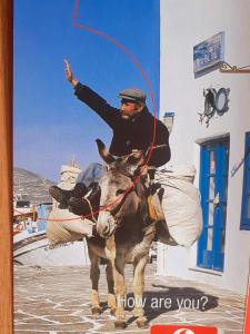 a poster of a man riding a donkey at Margarita Studios in Parikia