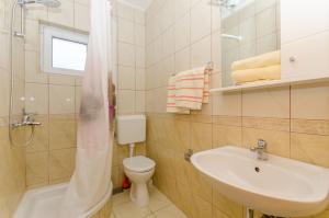 y baño con lavabo, aseo y ducha. en Knezovicapartments, en Živogošće