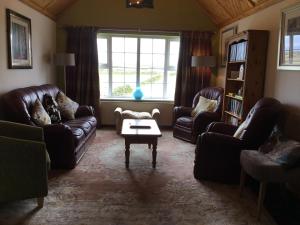 sala de estar con sofás de cuero y mesa de centro en Atlantic View House, en Doolin