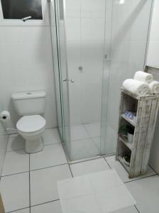 a bathroom with a toilet and a glass shower at AP Confortável San Inácio in Santo Ângelo