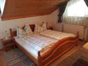 ein Schlafzimmer mit einem Holzbett mit Kissen in der Unterkunft Ferienwohnungen Eggarter in Fresach