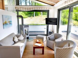 een woonkamer met een bank en stoelen en een open haard bij Villa "Paula" F501 - Penthouse strandnah mit Kamin und umlaufender Dachterrasse in Ostseebad Sellin