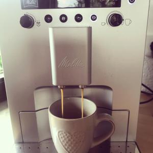 a cup of coffee is being brewed in a coffee machine at Spechtstraße 65 Ferienwohnung in Nordhorn