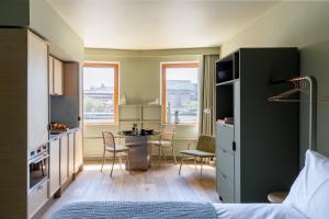 a bedroom with a bed and a kitchen with a table at Locke at Broken Wharf in London