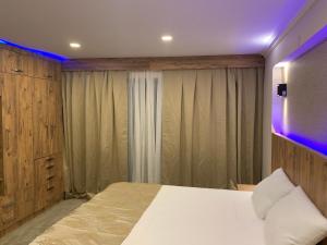 een slaapkamer met een wit bed en een paars licht bij NOUR SUITE & RESIDENCE in Istanbul