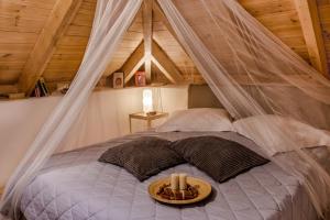 ein Bett mit Baldachin und einem Tablett mit Essen drauf in der Unterkunft Sinanis Garden House in Volos