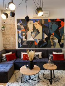 una sala de estar con un sofá azul y una pintura en Apartment Luxury Palace No1, en Split