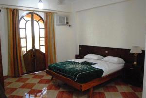 ein Schlafzimmer mit einem Bett und einem großen Fenster in der Unterkunft Leyla Eco Resort in Luxor