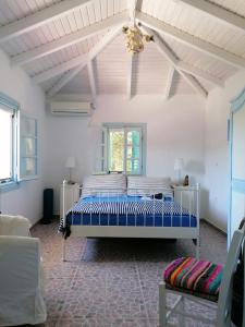 1 dormitorio con 1 cama en una habitación blanca en Lemon Tree Cottage, en Finikounta