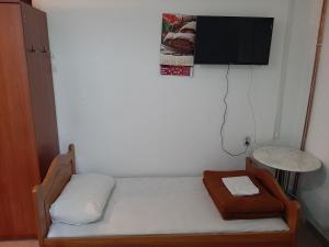 um pequeno quarto com uma cama e uma televisão na parede em Apartmani Herceg em Gacko