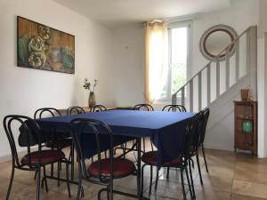 ein Esszimmer mit einem blauen Tisch und Stühlen in der Unterkunft LA BELLE ETOILE in Auneau