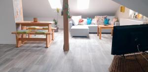 a living room with a white couch and wooden floors at Gartenlaube in Thale