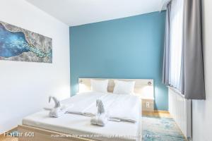 a bedroom with a bed with white sheets and two birds on it at Corvin Plaza Apartments & Suites in Budapest