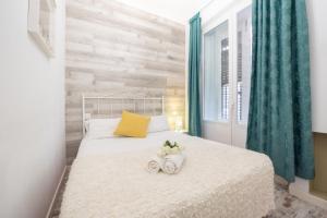 um quarto com uma cama branca e 2 toalhas em Apartamentos Day Madrid PLAZA DE ESPAÑA Centro Gran Via Sol Malasaña em Madri