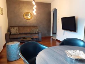 sala de estar con mesa, sillas y sofá en Appartements König, en Merano