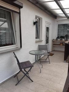 un patio con 2 sillas, una mesa y una ventana en Ferienwohnung Runge I, en Schönhauser Damm